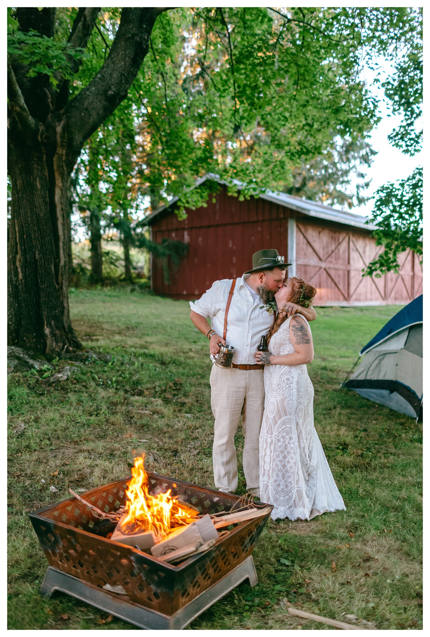 hippie bride and groom kiss by camp fire