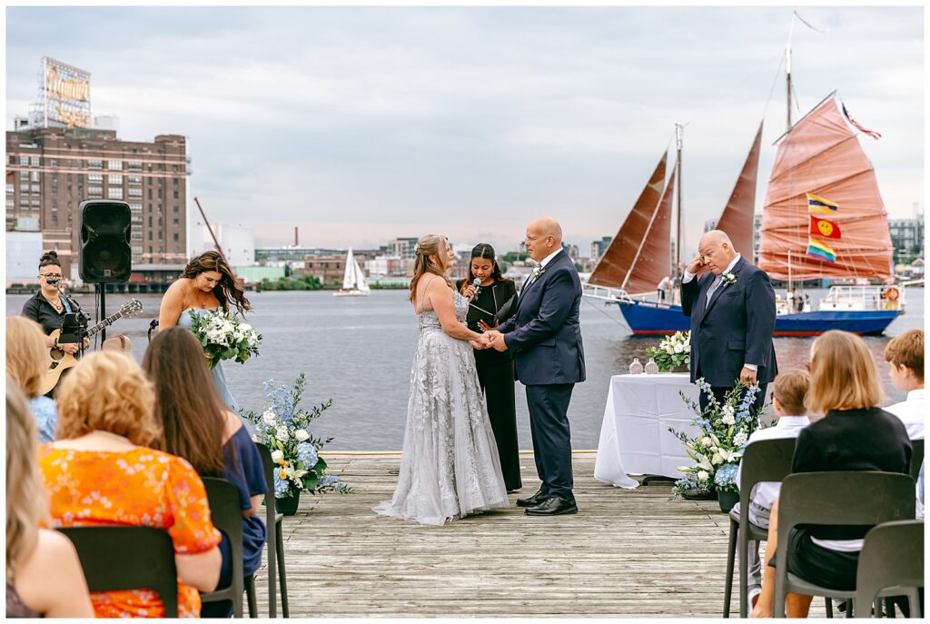 New York wide shot of wedding on dock overlooking harbor and water