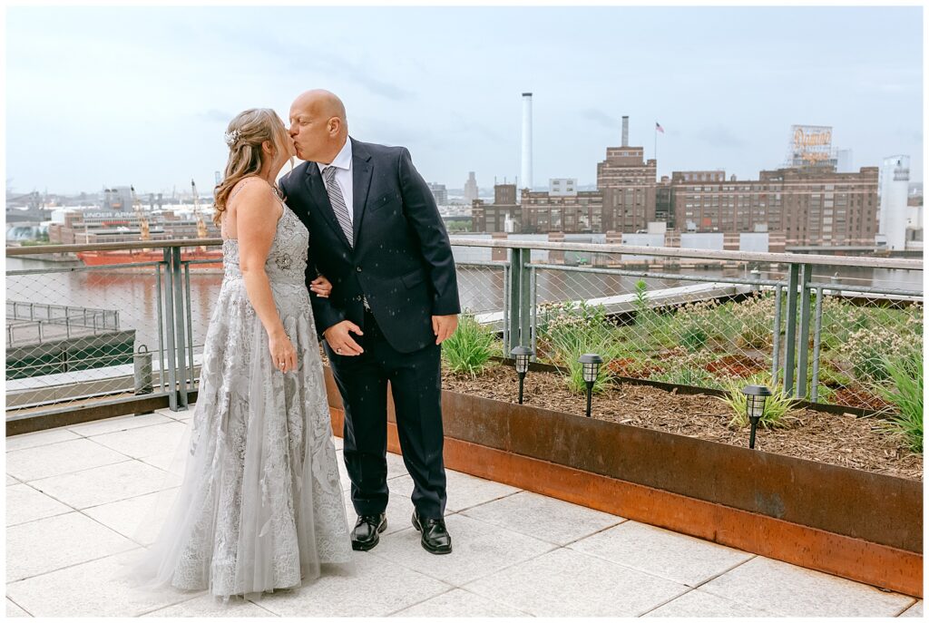 New York bride and groom portrait kissing on rooftop after their first look