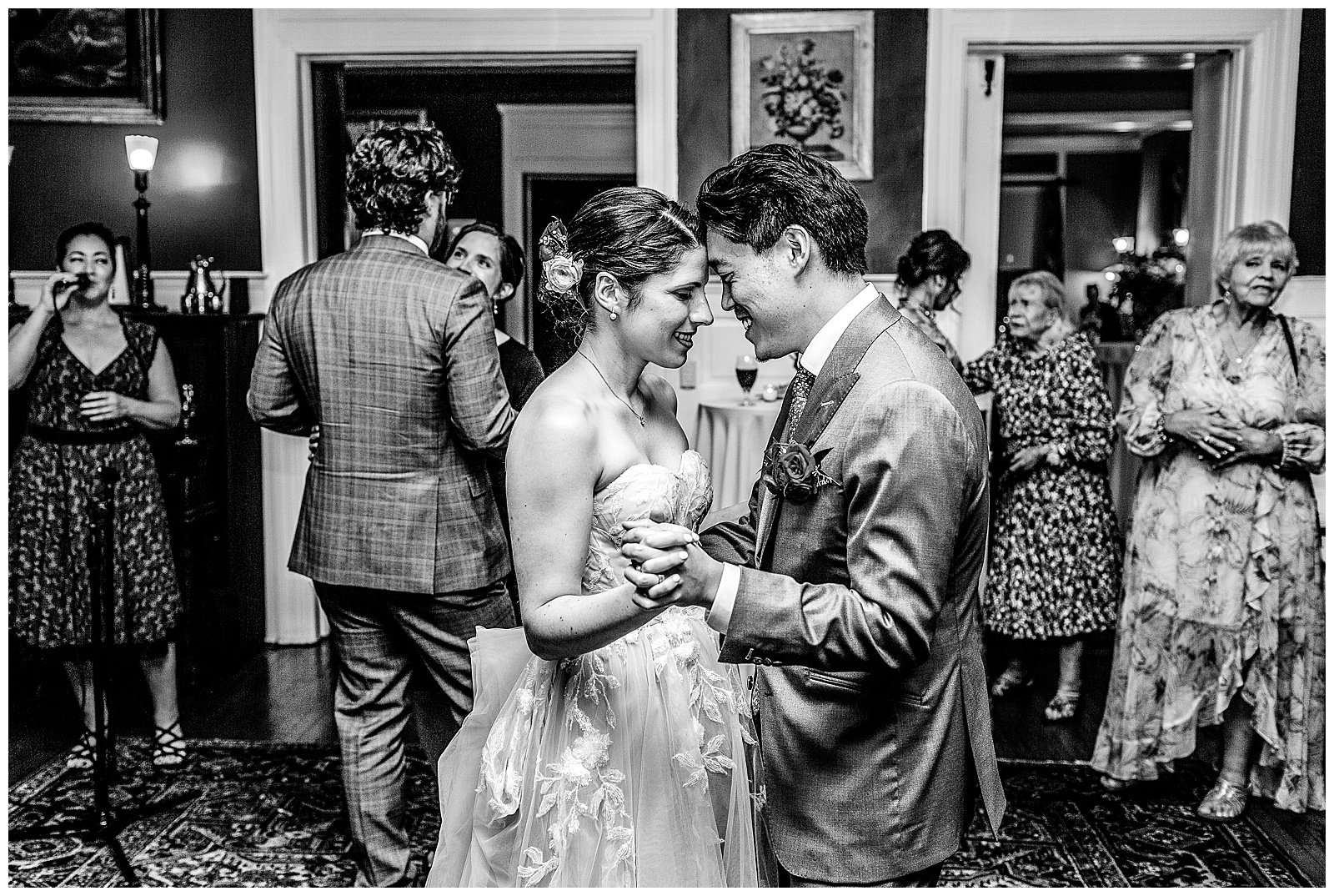 Intimate dance floor moment with bride and groom foreheads together dancing