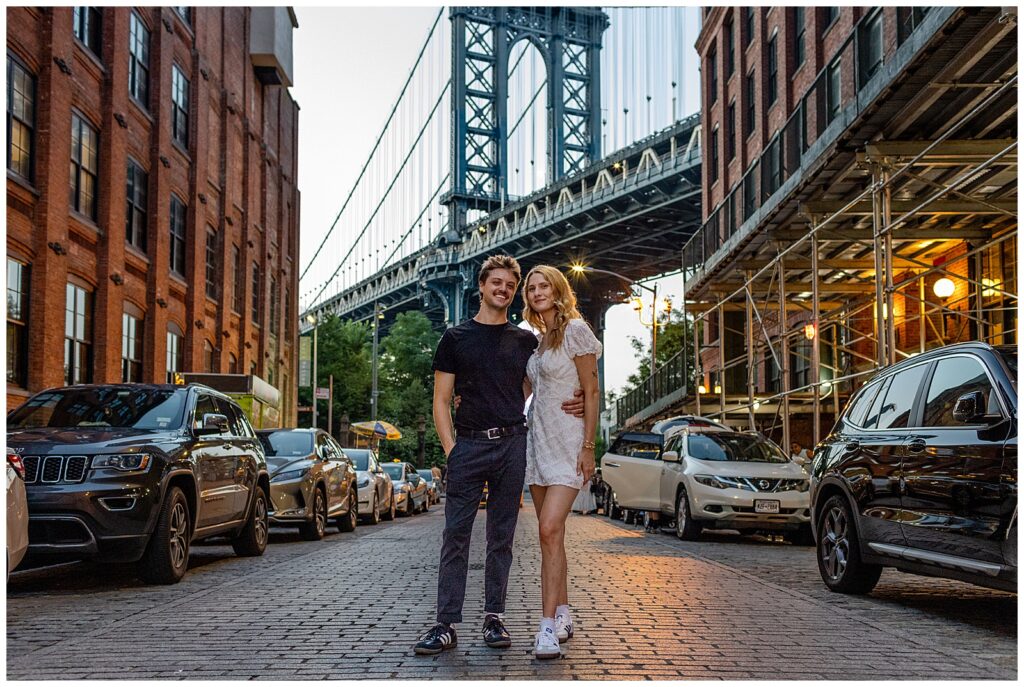 Brooklyn New York couple stand under Dumbo - Manhattan Bridge View for their engagement session