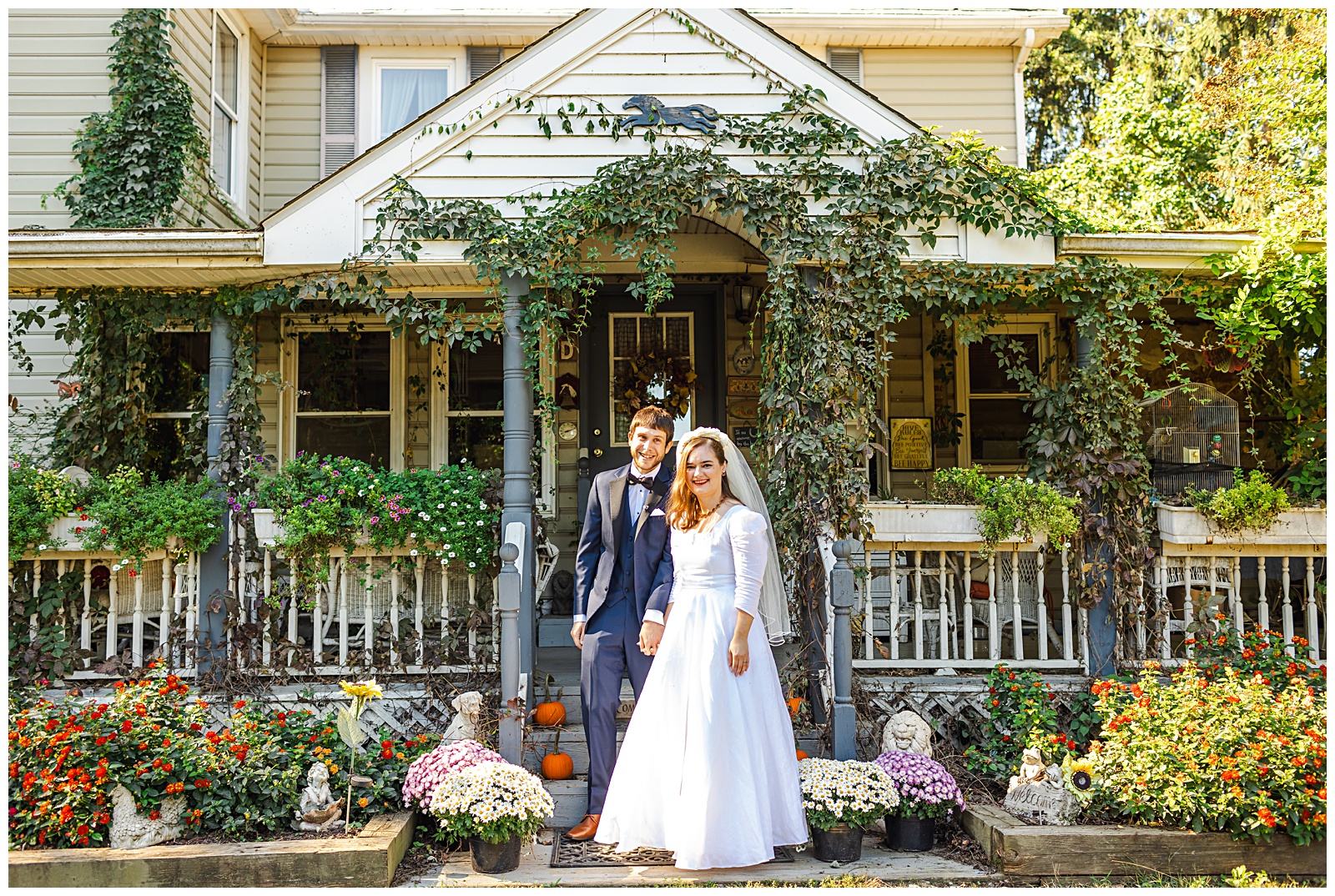 smiling portrait of bride and groom in front of Fairwinds Farm porch