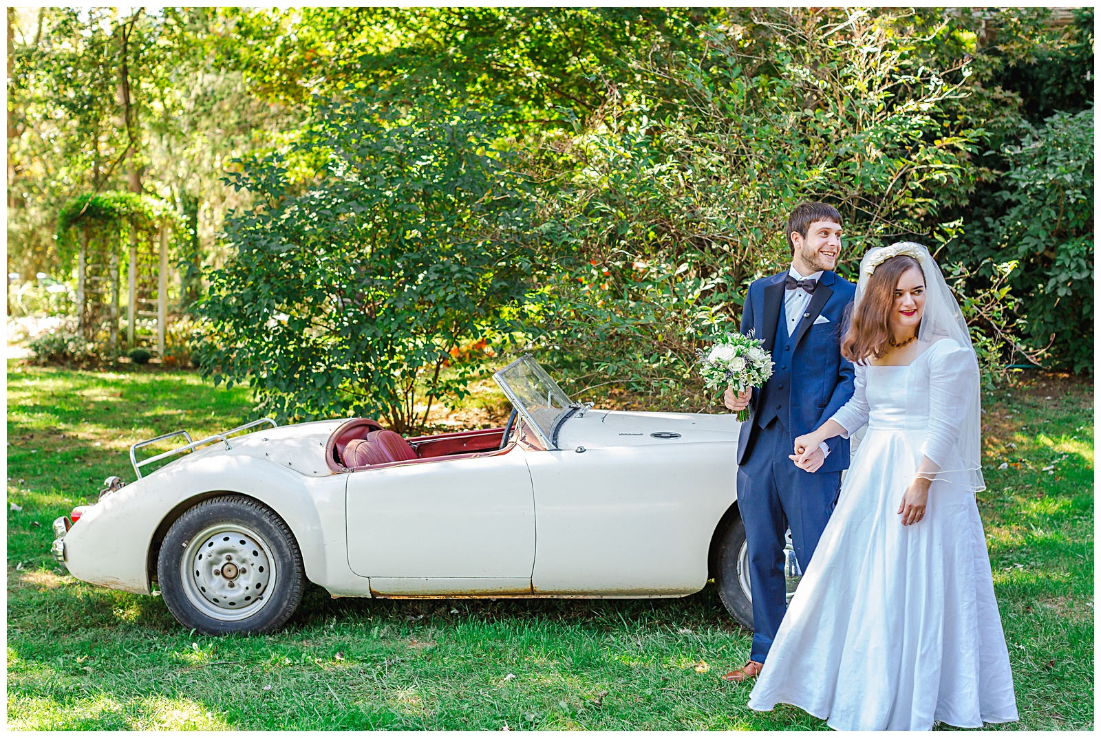 candid photo of bride and groom by antique car