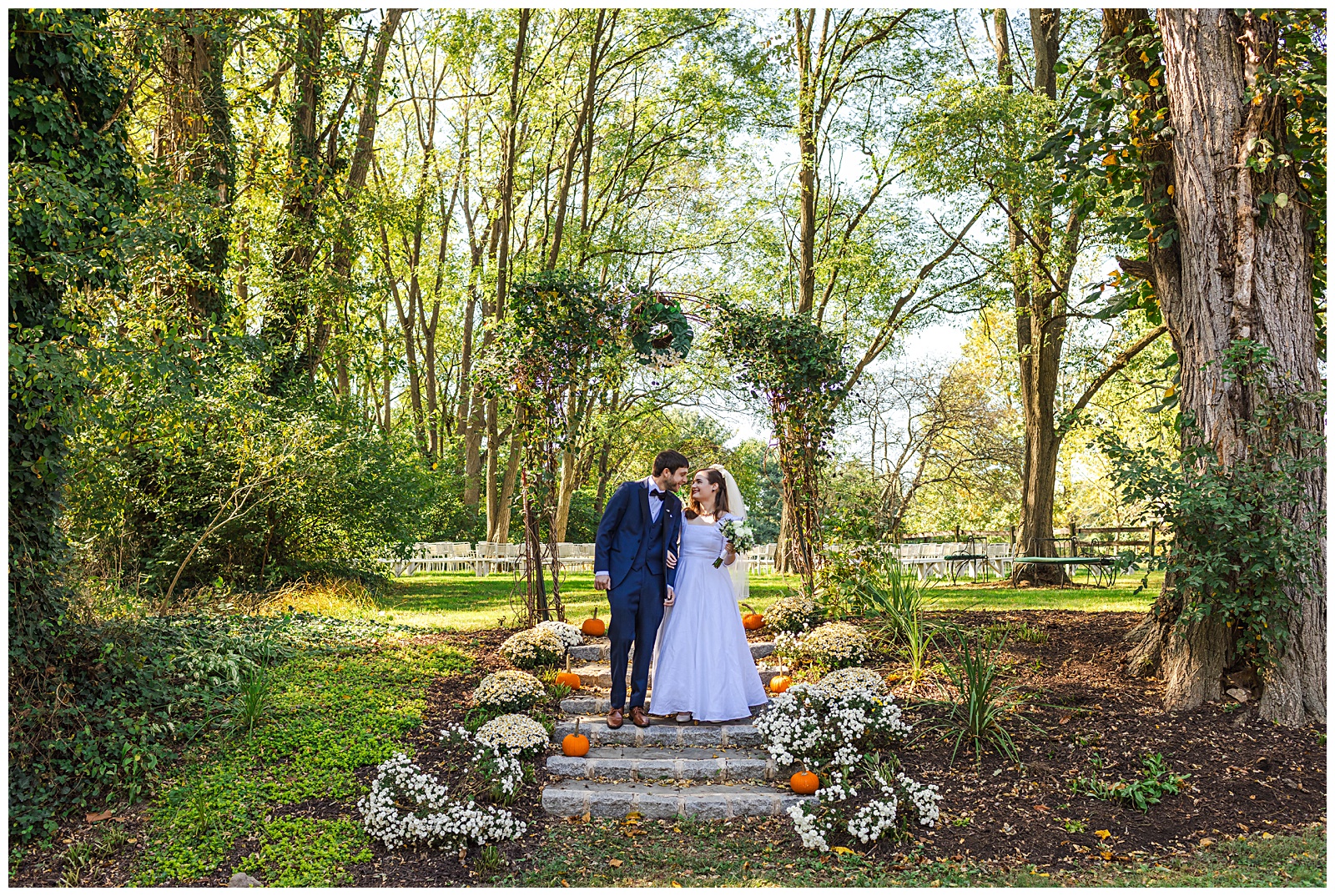 October portrait of bride and groom walking down stairs that are lined with pumpkins