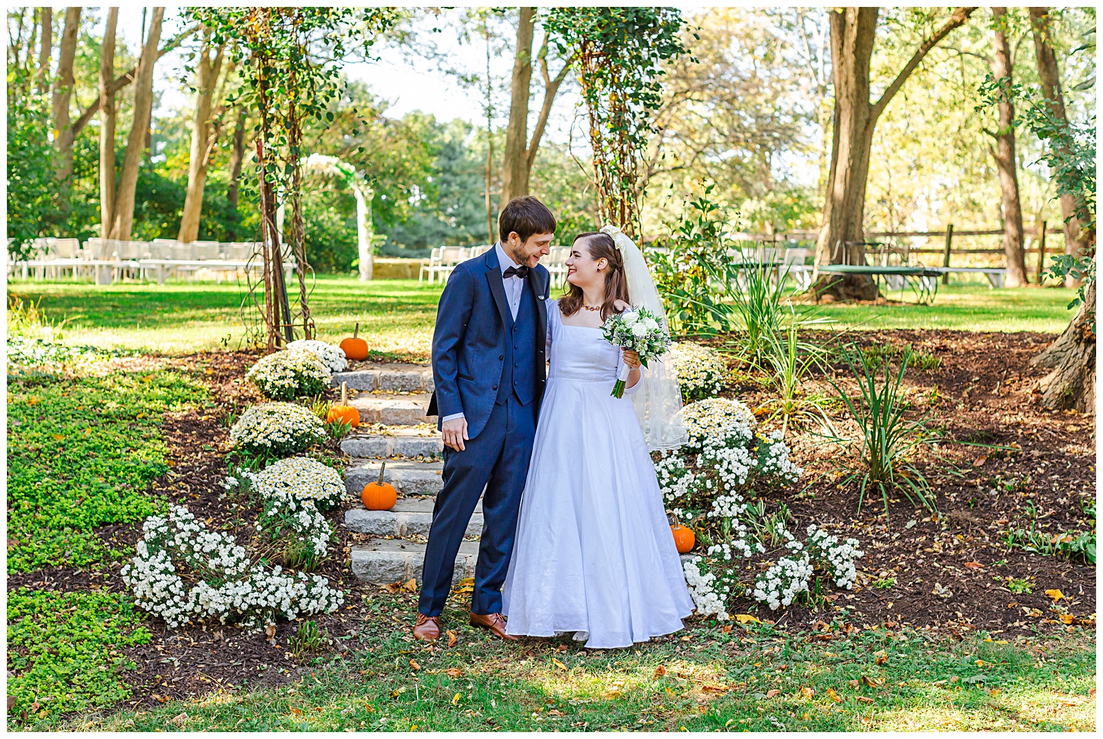 bride and groom looking at each other standing in front of stair walkway that is lined with pumpkins