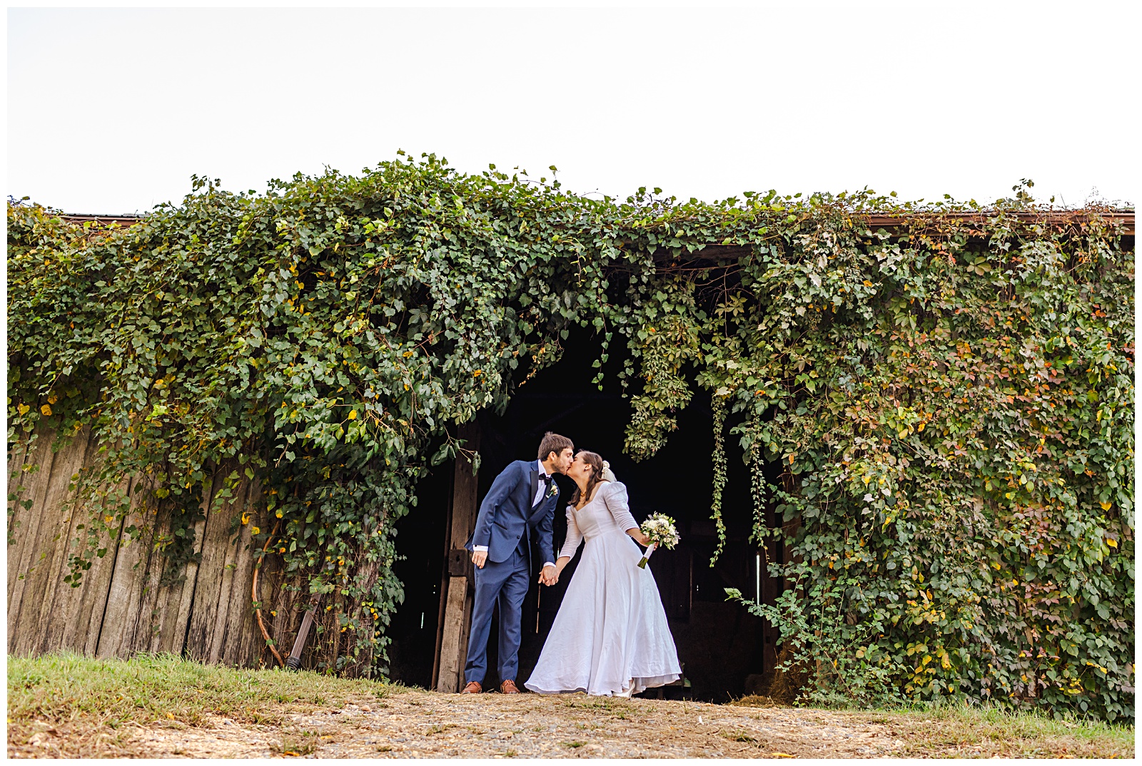 kissing portrait of bride and groom on wedding day at rustic barn venue