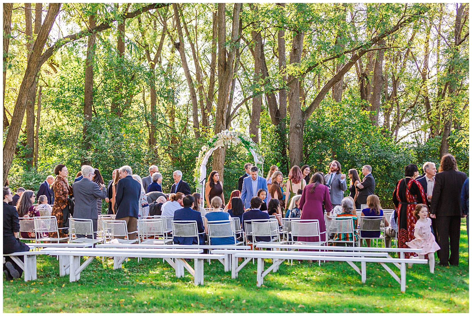 guests greeting each other as they arrive and are seated for the wedding ceremony