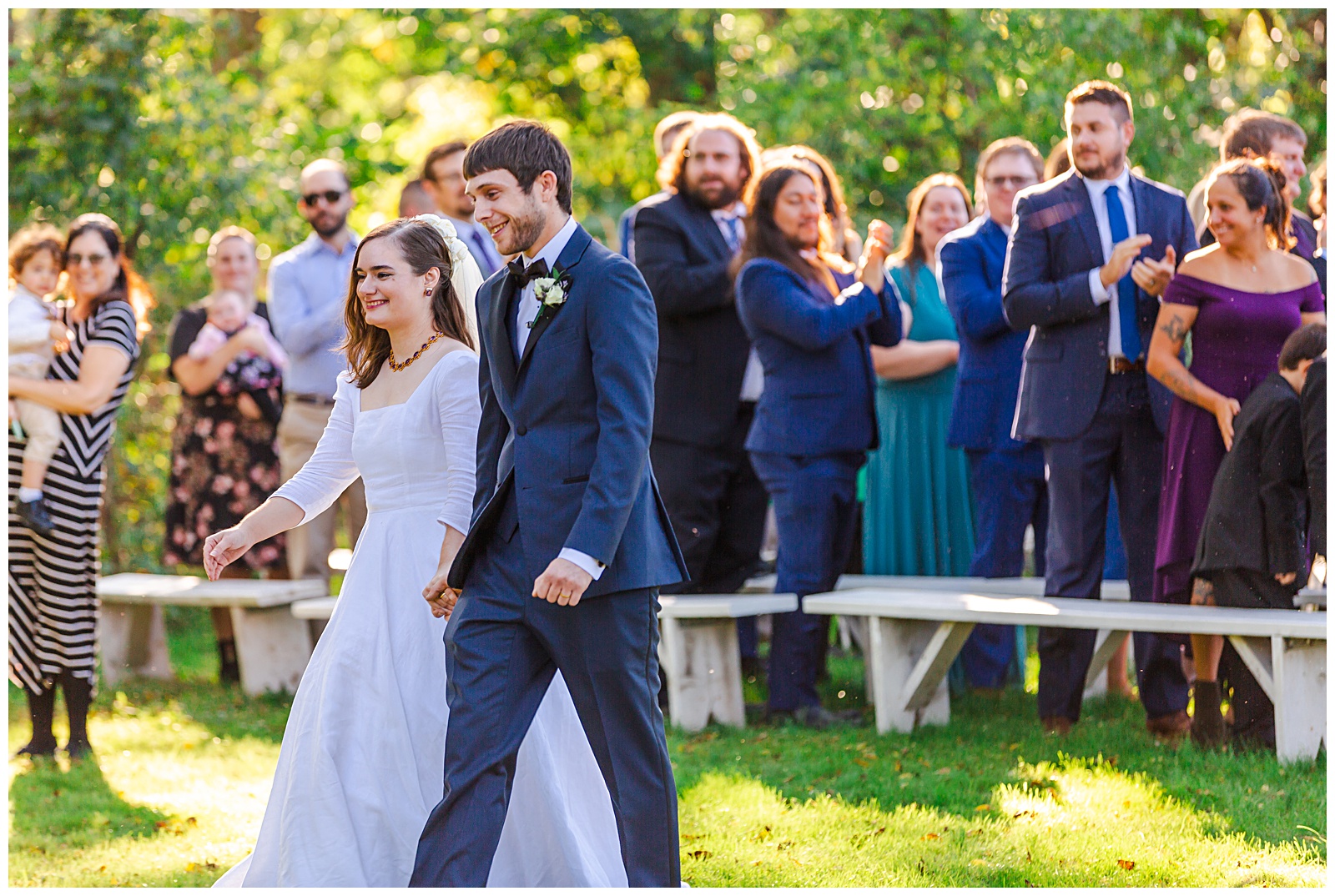 bride and groom smile as the recess down the walkway as just married husband and wife at Romantic Autumn Wedding at Fairwinds