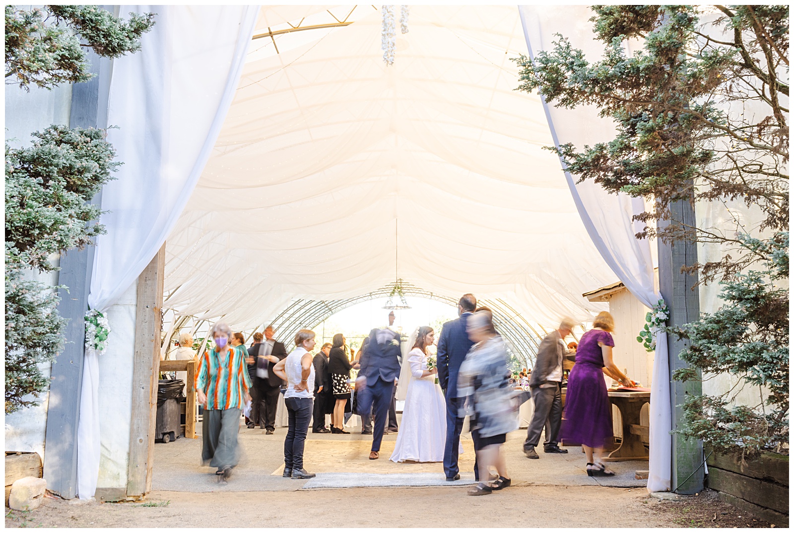 blurred movement image of guests walking around at wedding reception barn at Romantic Autumn Wedding at Fairwinds