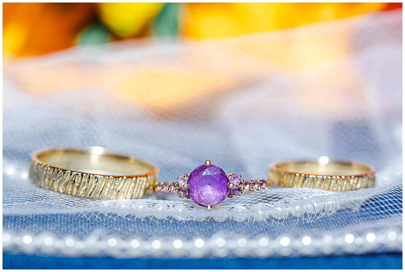 close up detail shot of wedding couples rings with purple gemstone