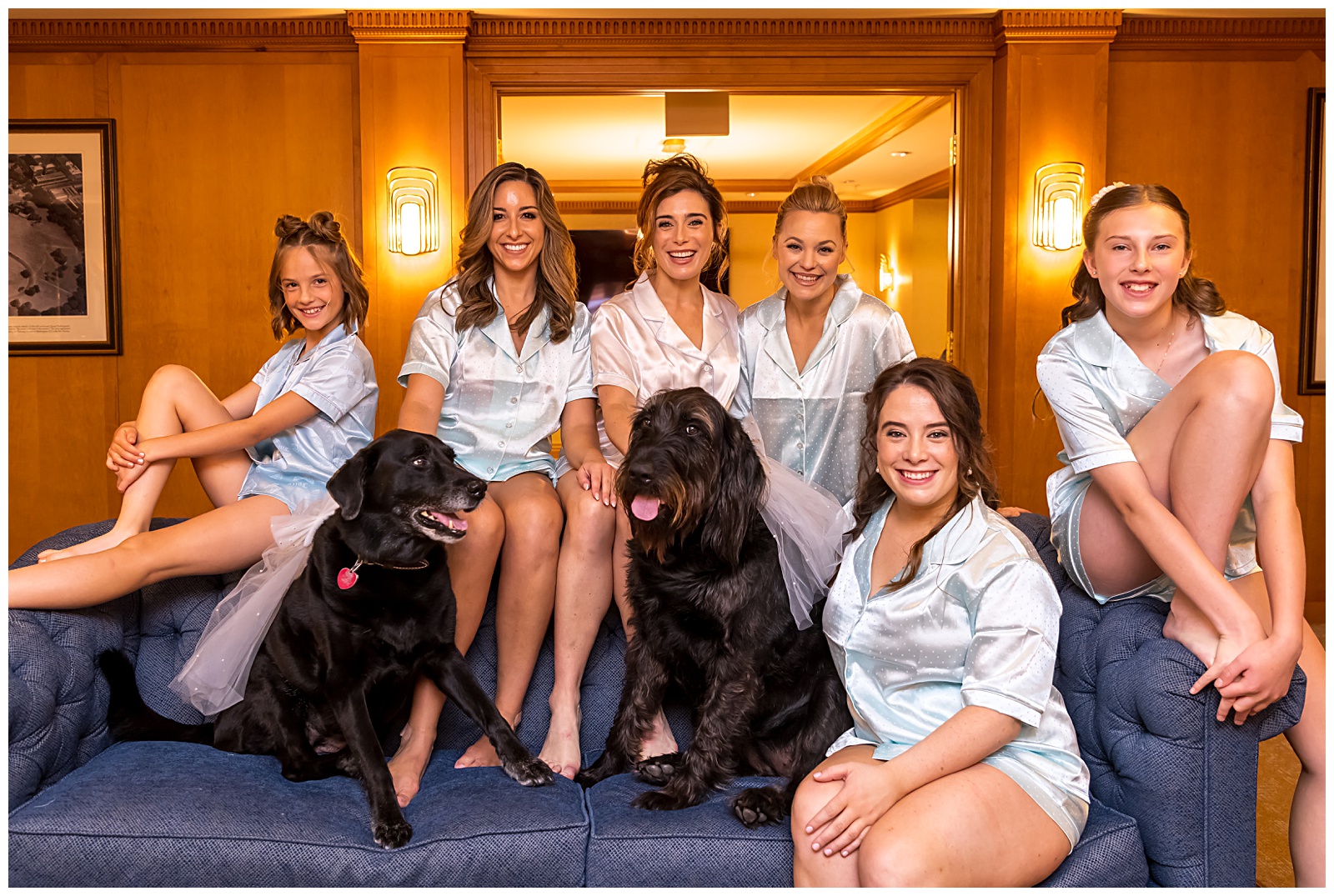 Bridesmaids in matching pajamas laughing with dogs before DC wedding
