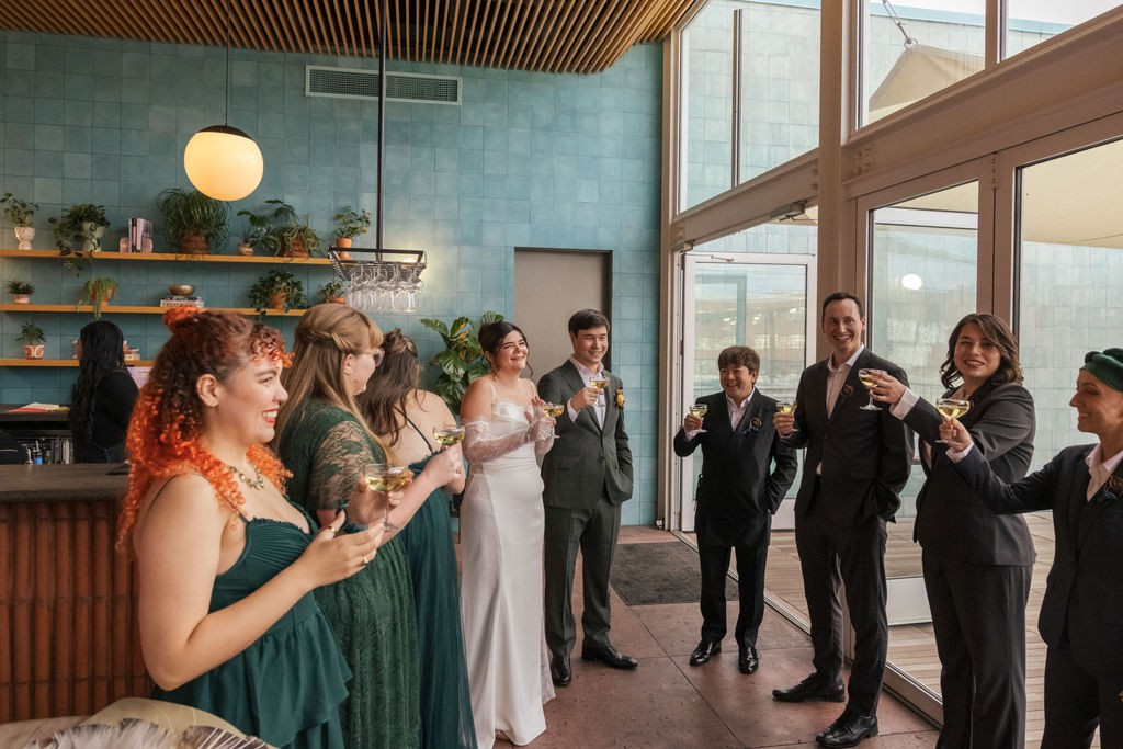 Wedding party raising glasses before the ceremony at a relaxed Brooklyn brewery wedding.