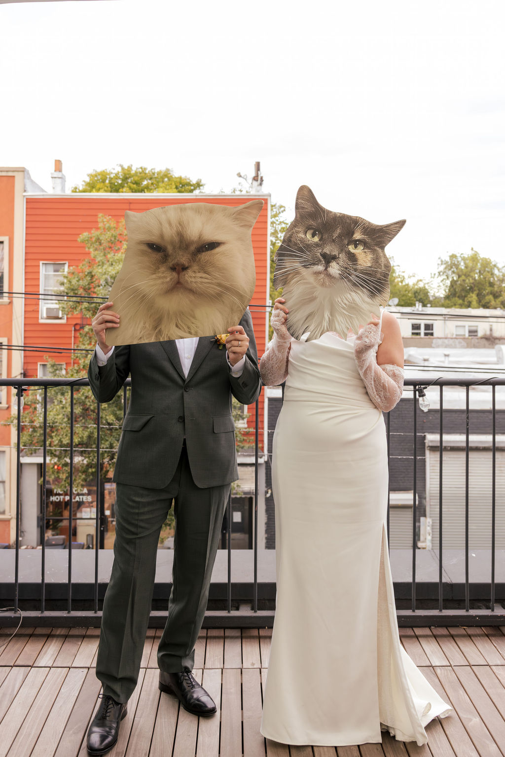 Couple holding oversized cat cutouts during a playful non traditional wedding in Brooklyn NYC.
