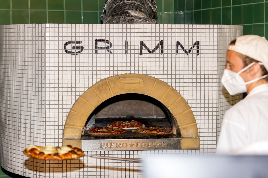 Wood fired pizza oven serving guests during a casual Brooklyn brewery wedding reception.