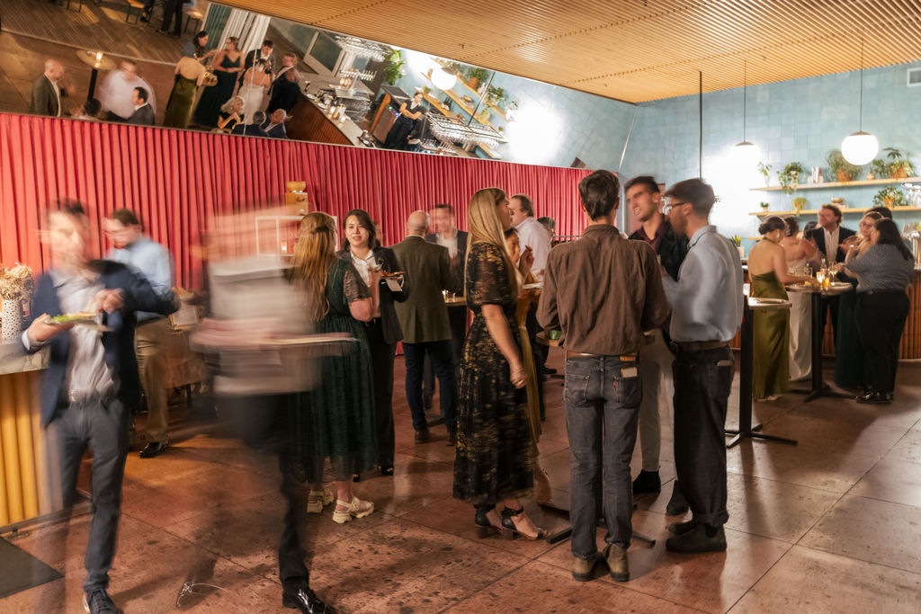 Guests mingling during an open bar pizza party at a Brooklyn brewery wedding.