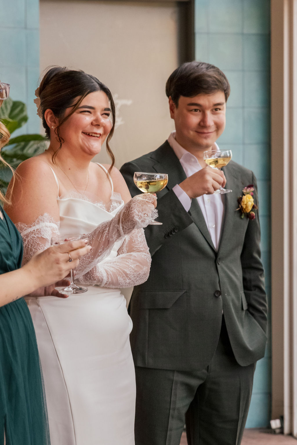 Couple raising glasses during toasts at an intimate Brooklyn brewery wedding celebration.
