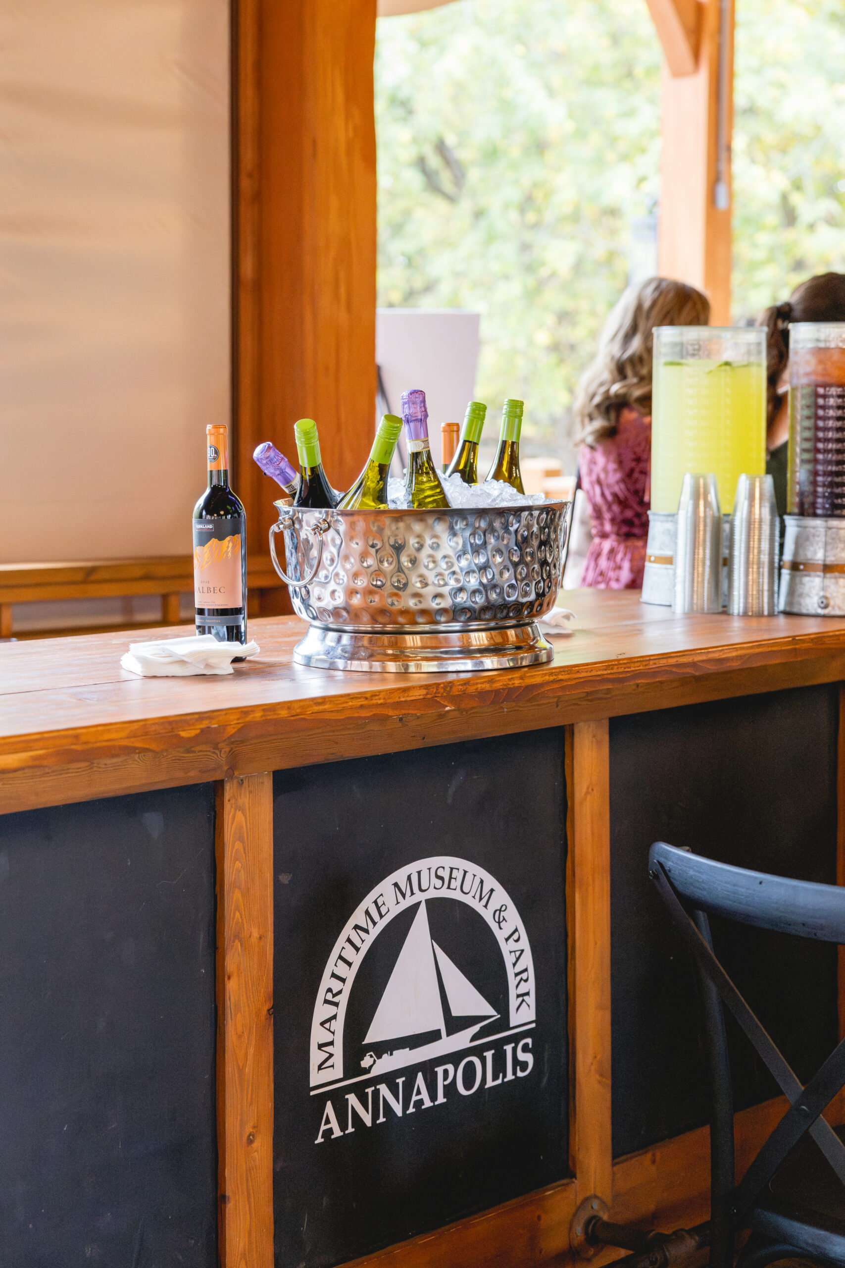 Wine bottles and drink dispensers displayed on the bar at an Annapolis Maritime Museum & Park wedding reception in Annapolis, Maryland