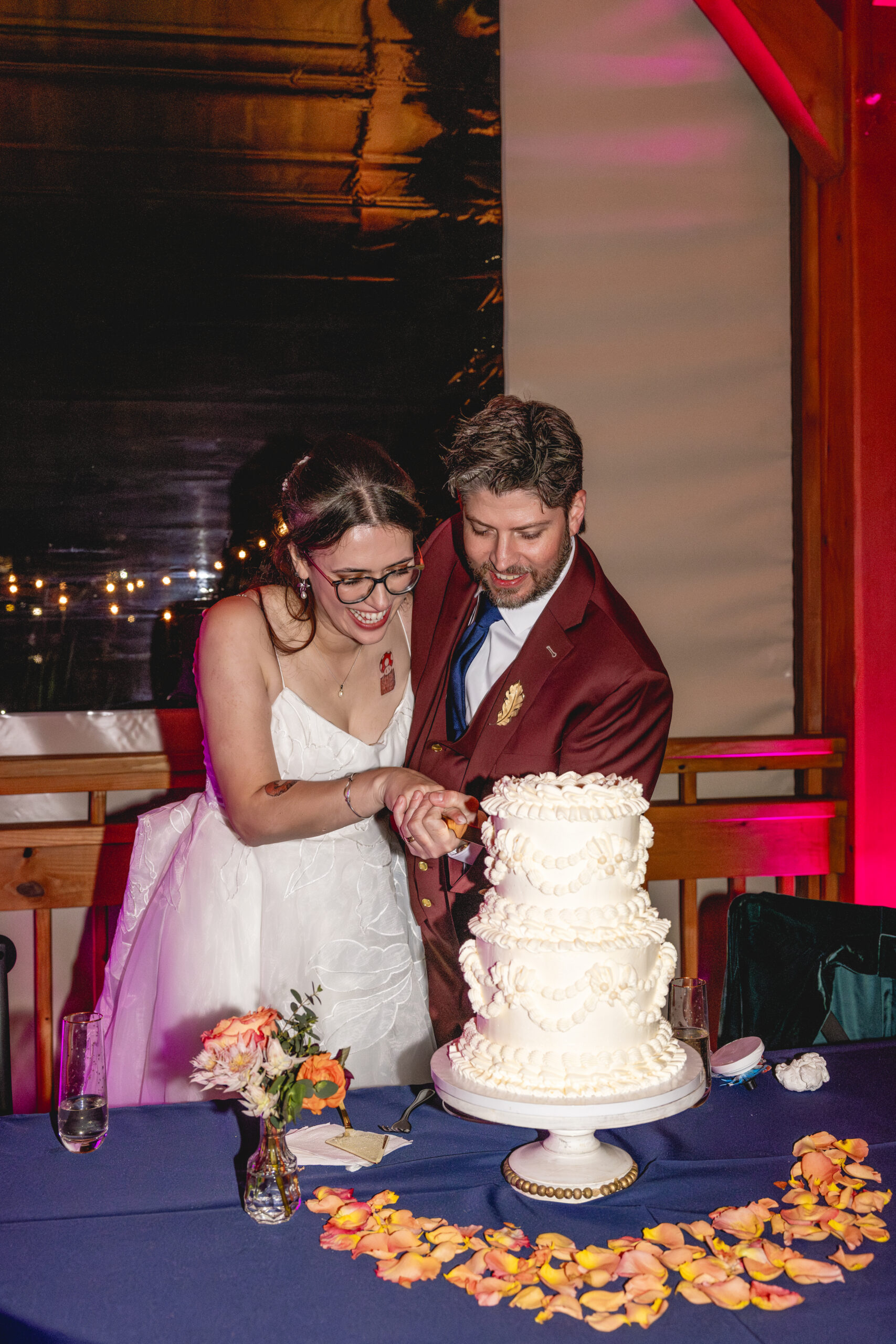 Bride and groom cutting their wedding cake together during their Annapolis Maritime Museum & Park wedding reception