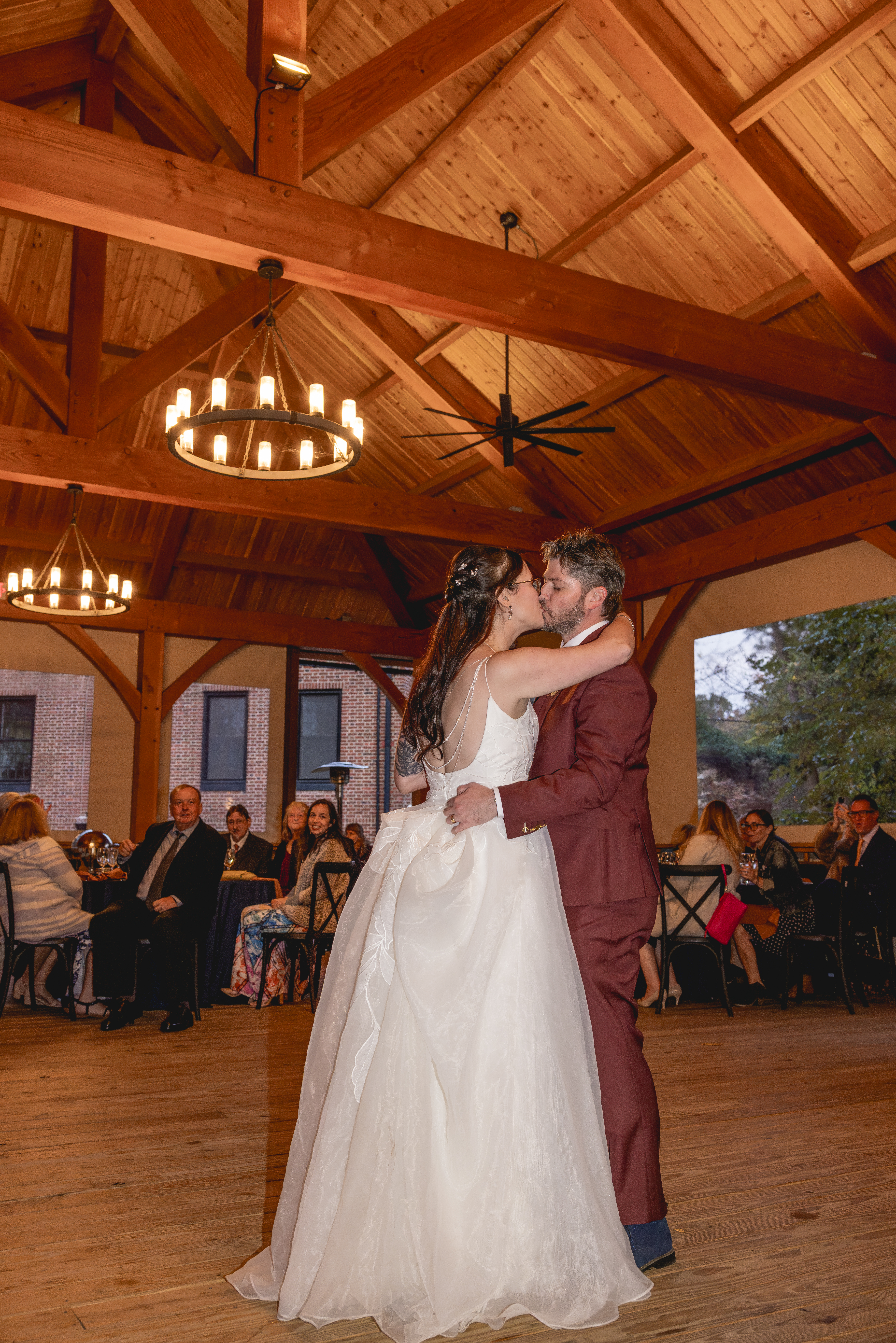 Bride and groom sharing their first dance under exposed wooden beams at their Annapolis Maritime Museum & Park wedding