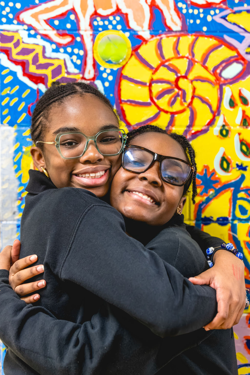 two girls students embracing each other during afterschool