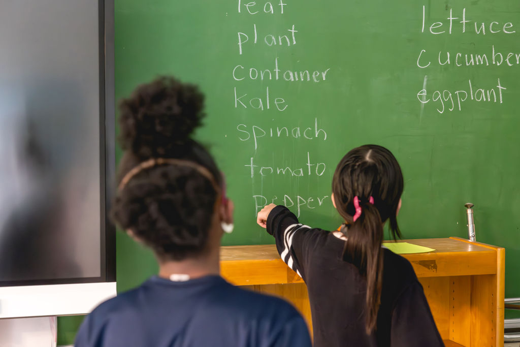 Documentary school photography of students learning at chalkboard during class at P.S. 272 Curtis Estabrook in New York