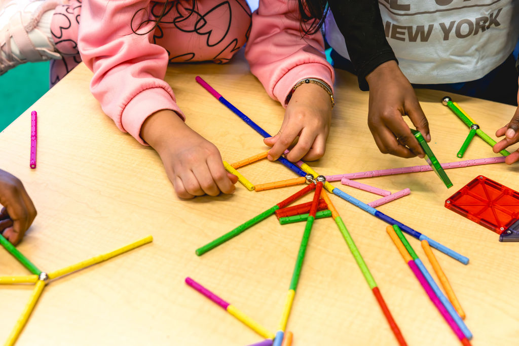 Documentary school photography of students building with colorful blocks during after-school program at P.S. 272 Curtis Estabrook