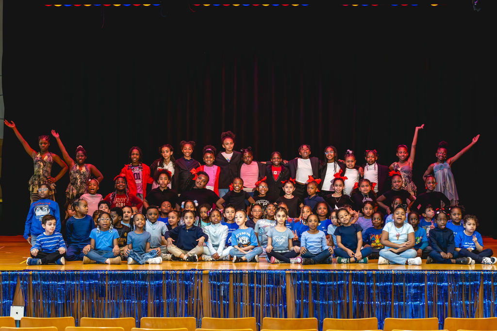 Group portrait of students on stage during school performance at P.S. 272 Curtis Estabrook in New York