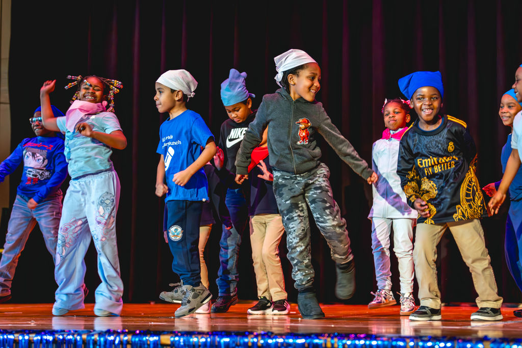 Students dancing on stage during after-school performance at P.S. 272 Curtis Estabrook in Brooklyn