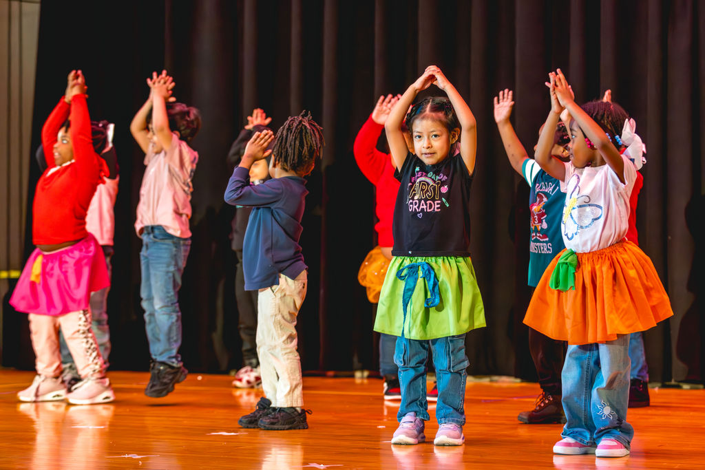 Students performing choreographed dance on stage at P.S. 272 Curtis Estabrook after-school showcase