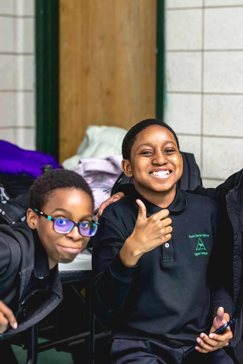 Joyful after-school students sharing a candid moment through documentary school photography at Excel Upper School