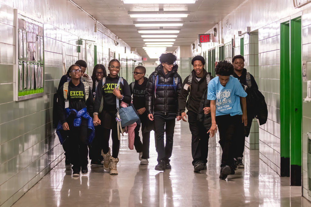 Documentary school photography of after-school students walking together through school hallway at Excel Upper School