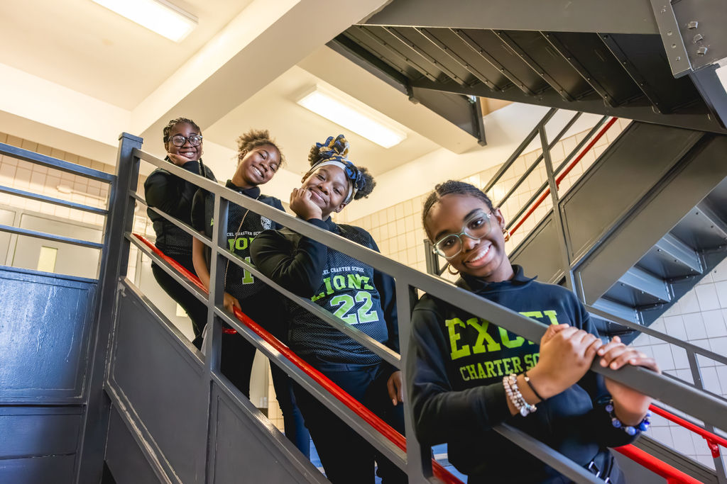 Confident after-school students smiling on school staircase in documentary school photography at Excel Upper School