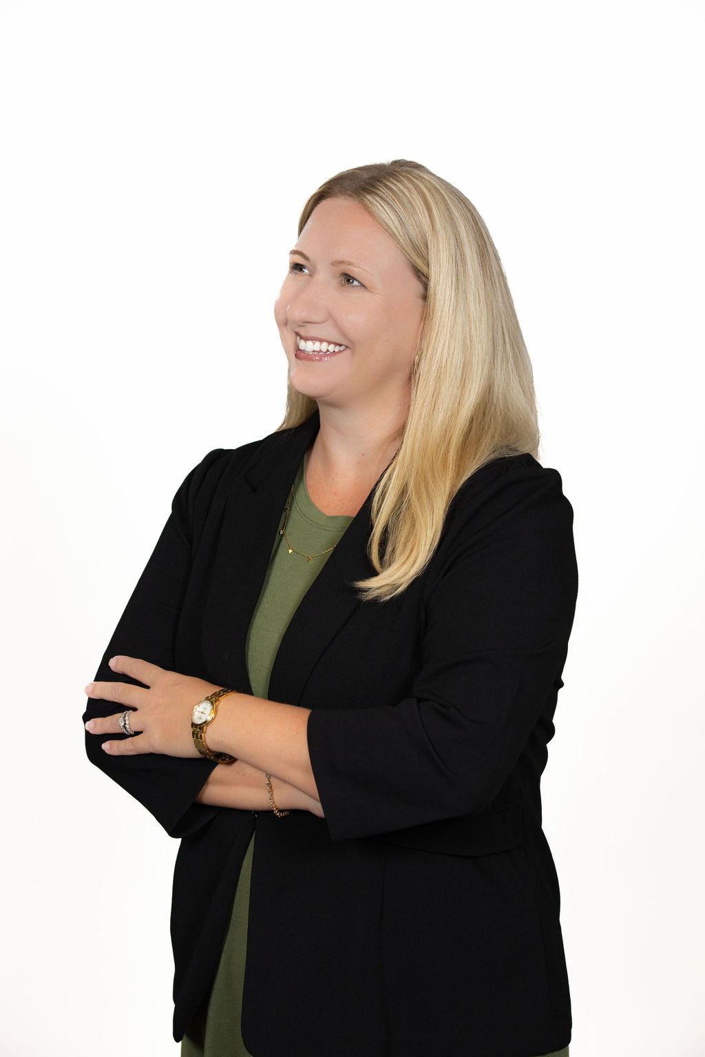 Three quarter body professional headshot of a woman with blonde hair wearing a black blazer over a green top, arms crossed, white background by Liz Stewart Photography DC