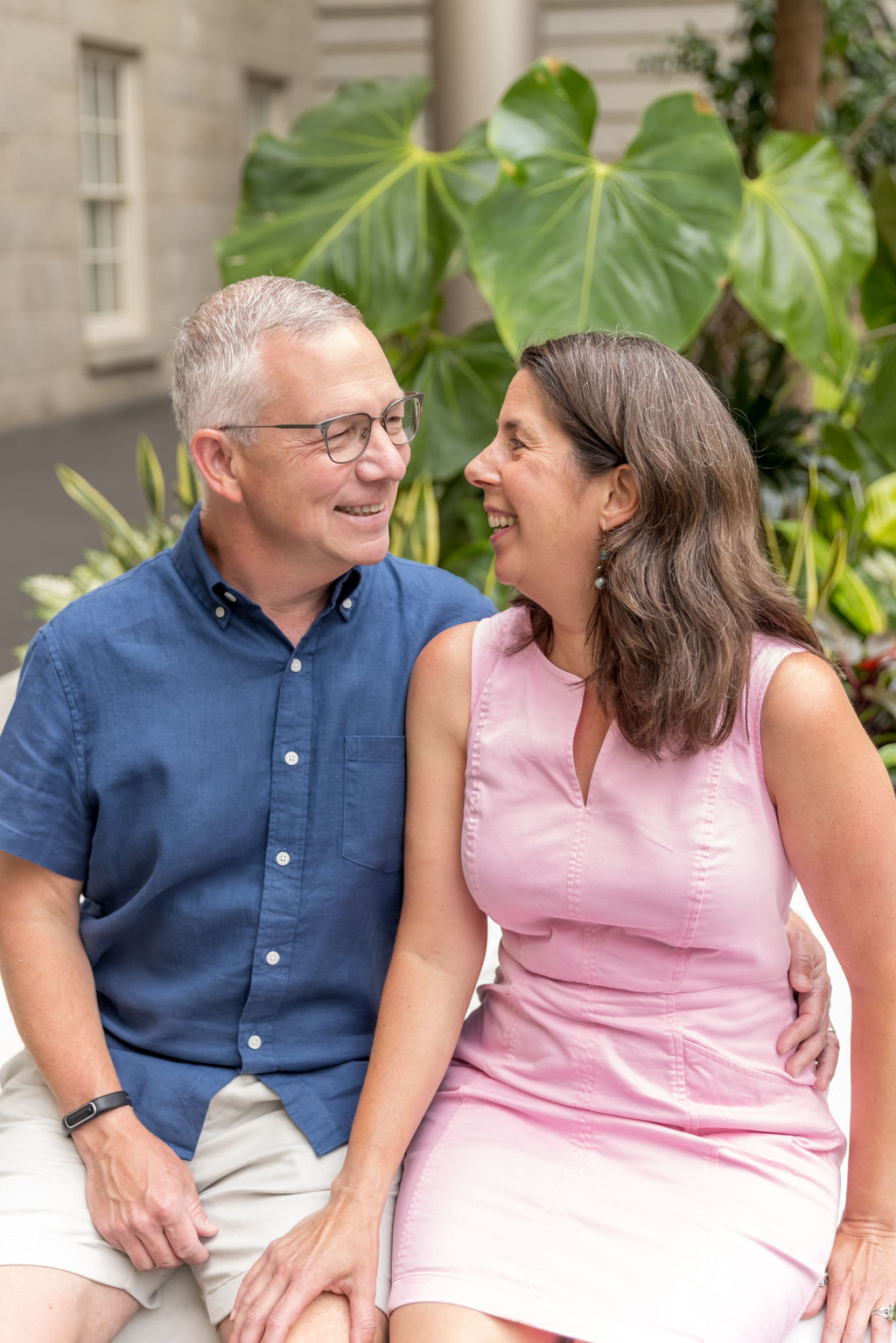 Couple sharing a laugh on a stone bench in the atrium garden at the National Portrait Gallery, one of Washington DC's most accessible indoor photoshoot locations