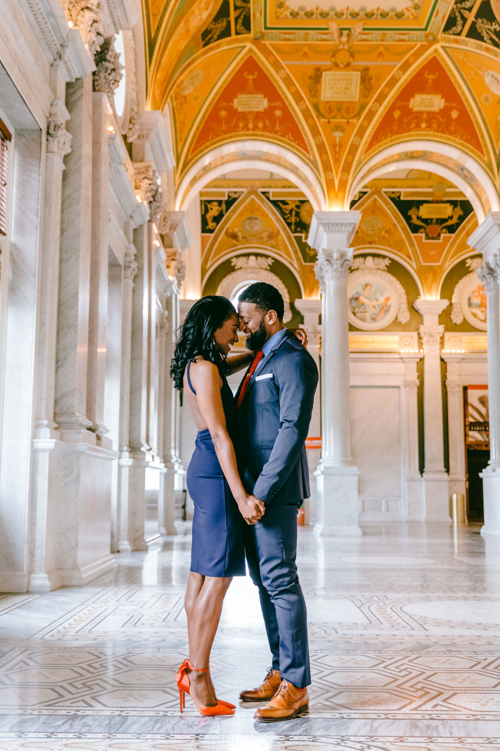 Couple sharing a tender moment with foreheads touching in a warmly lit corridor of the Library of Congress in Washington DC